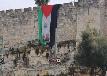 Why did a large Palestinian flag cover Jerusalem's city walls?