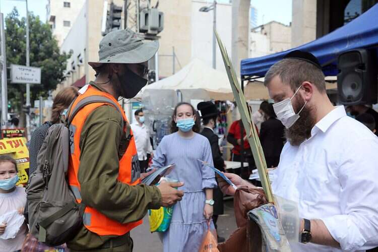 IDF soldier distributes coronavirus information pamphlets in Bnei Brak