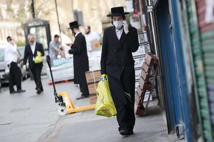 An Orthodox Jewish man wearing a protective face mask and gloves is seen in Stamford Hill