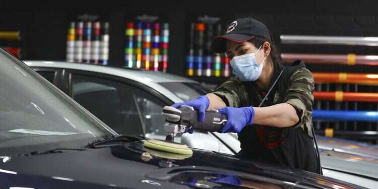 Iranian woman breaks taboos as she details cars at Tehran garage