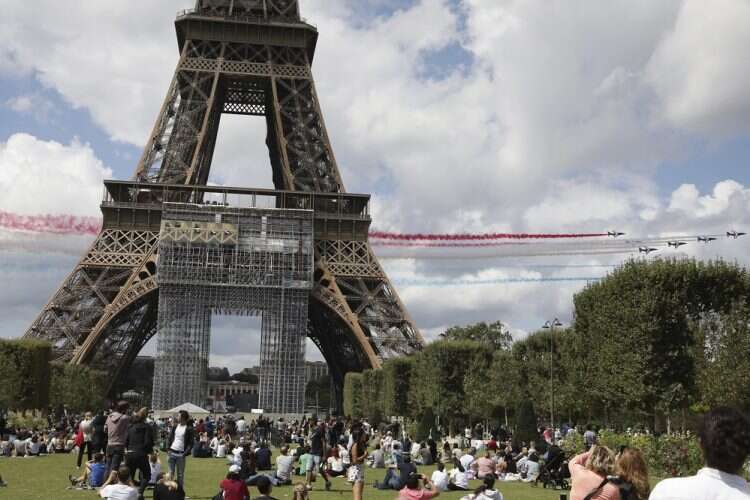 The French Aerial Patrol fly by the Eiffel Tower as celebrations are held in Paris as part of the Olympic handover ceremony