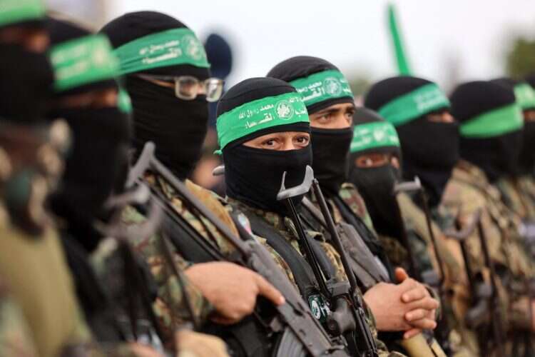 Hamas terrorists gather at the site of the handing over of two Israeli hostages in Rafah in the southern Gaza Strip,  on February 22, 2025